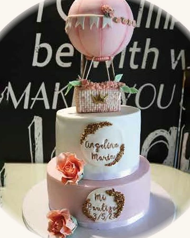 Tarta de bautizo de dos pisos con flores y globo aerostático en tonos empolvados
